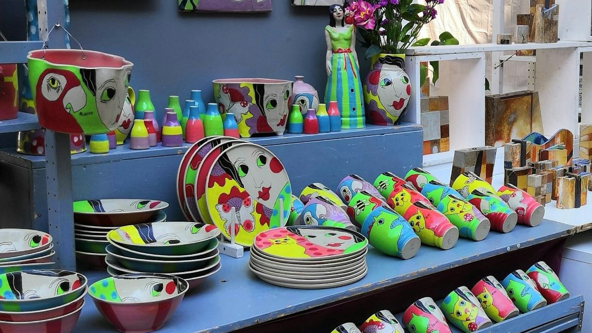 Bunte Tassen, Teller und Becher aus Ton.