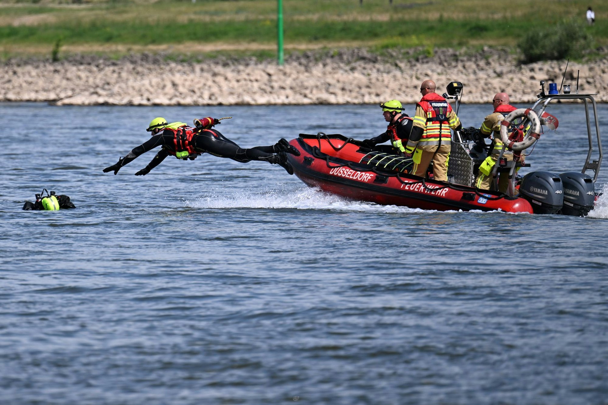 Schwimmen im Rhein ist lebensgefährlich - darauf weist die Feuerwehr Düsseldorf bei einer Übung hin.