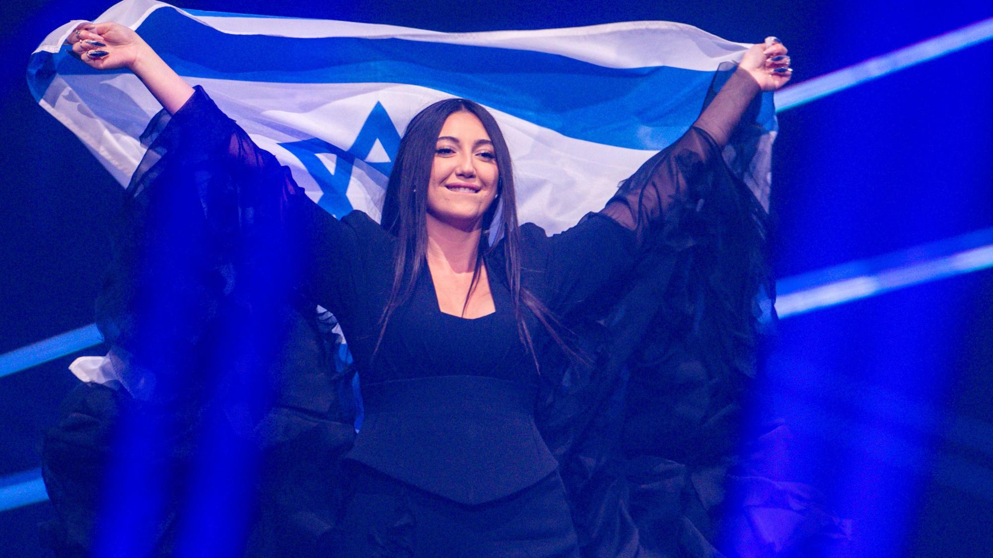 Yuval Raphael aus Israel kommt mit der Landesfahne bei einer Probe für die Finalshow des 69. Eurovision Song Contest in der Arena St. Jakobshalle auf die Bühne.