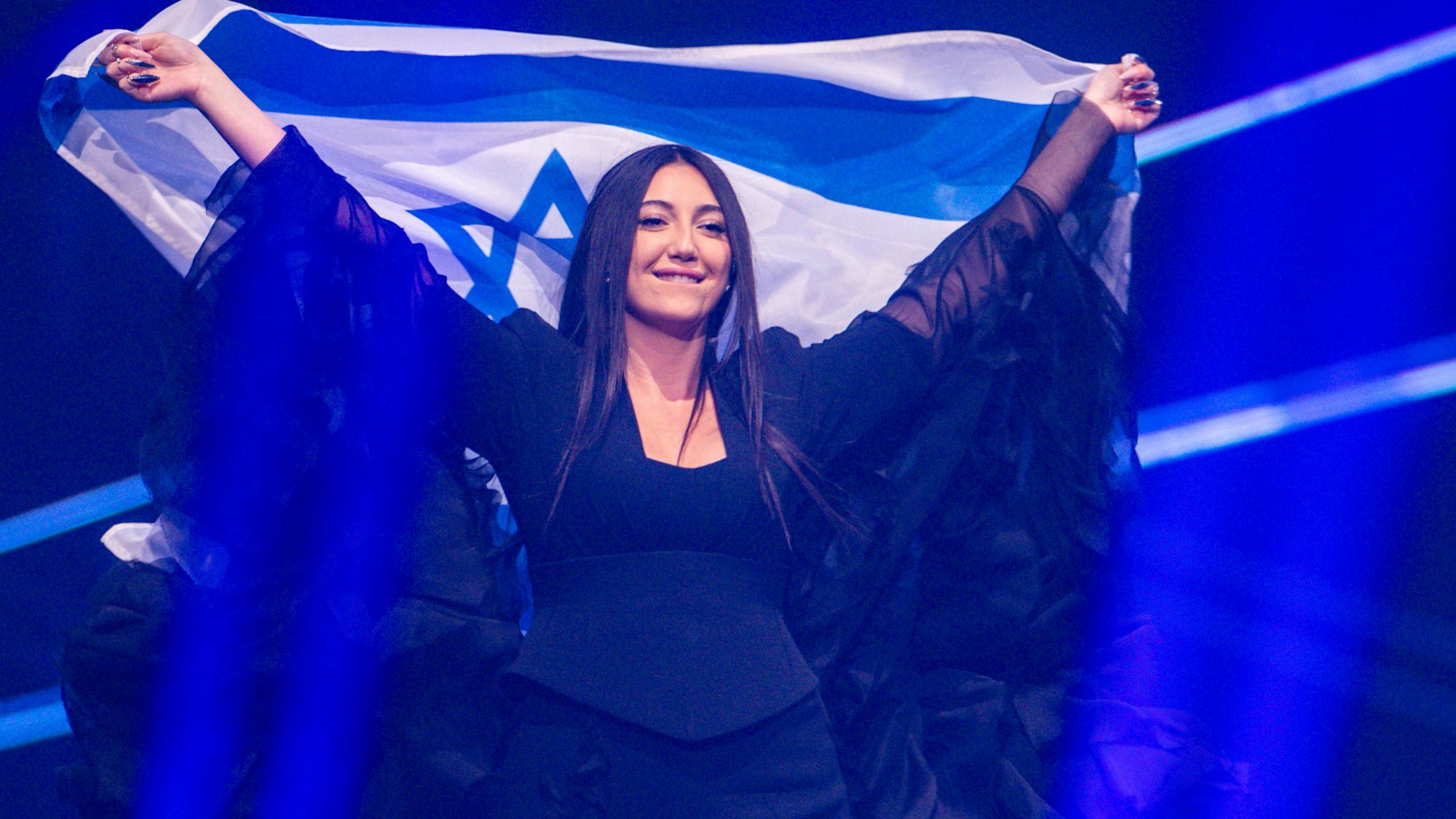 Yuval Raphael aus Israel kommt mit der Landesfahne bei einer Probe für die Finalshow des 69. Eurovision Song Contest in der Arena St. Jakobshalle auf die Bühne.