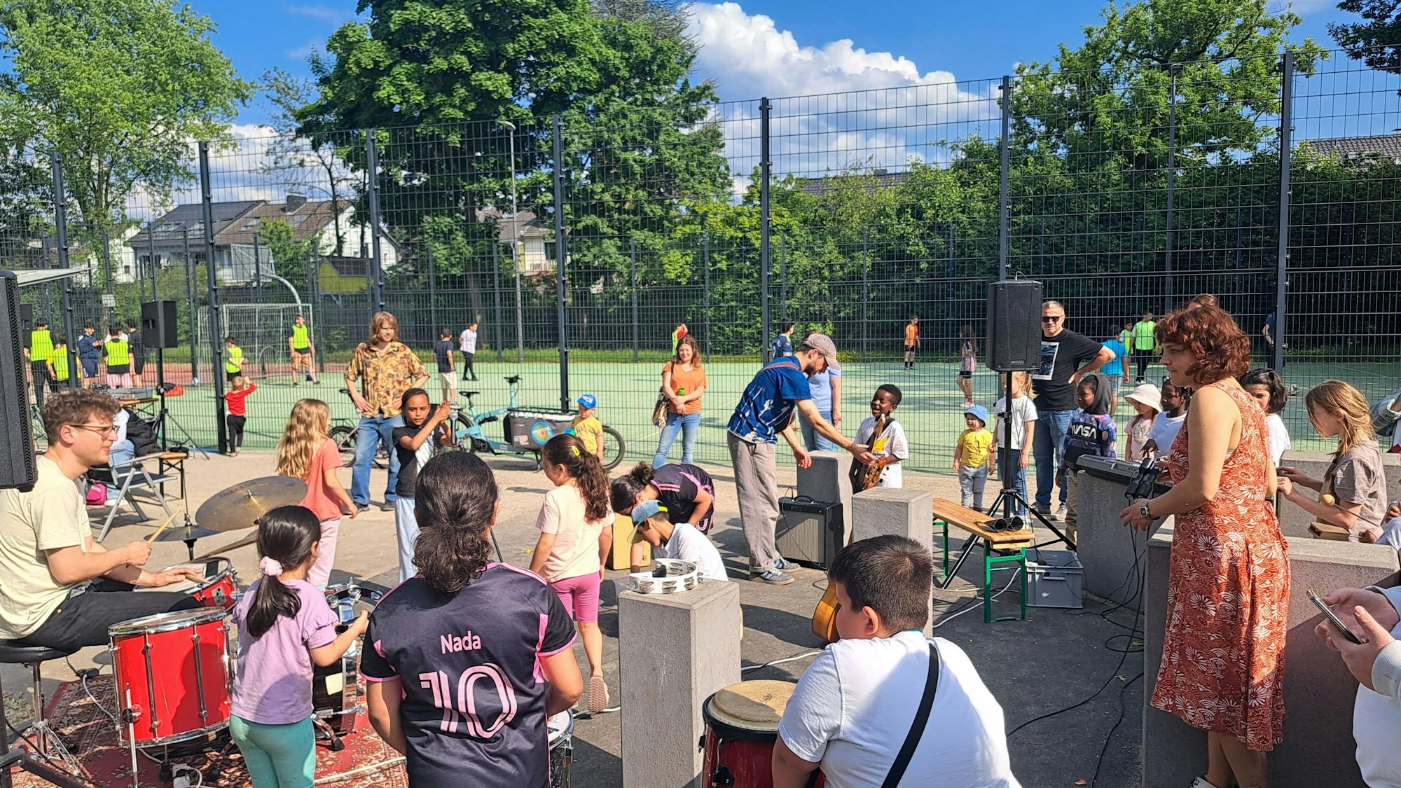 Kinder und Erwachsene musizieren gemeinsam draußen