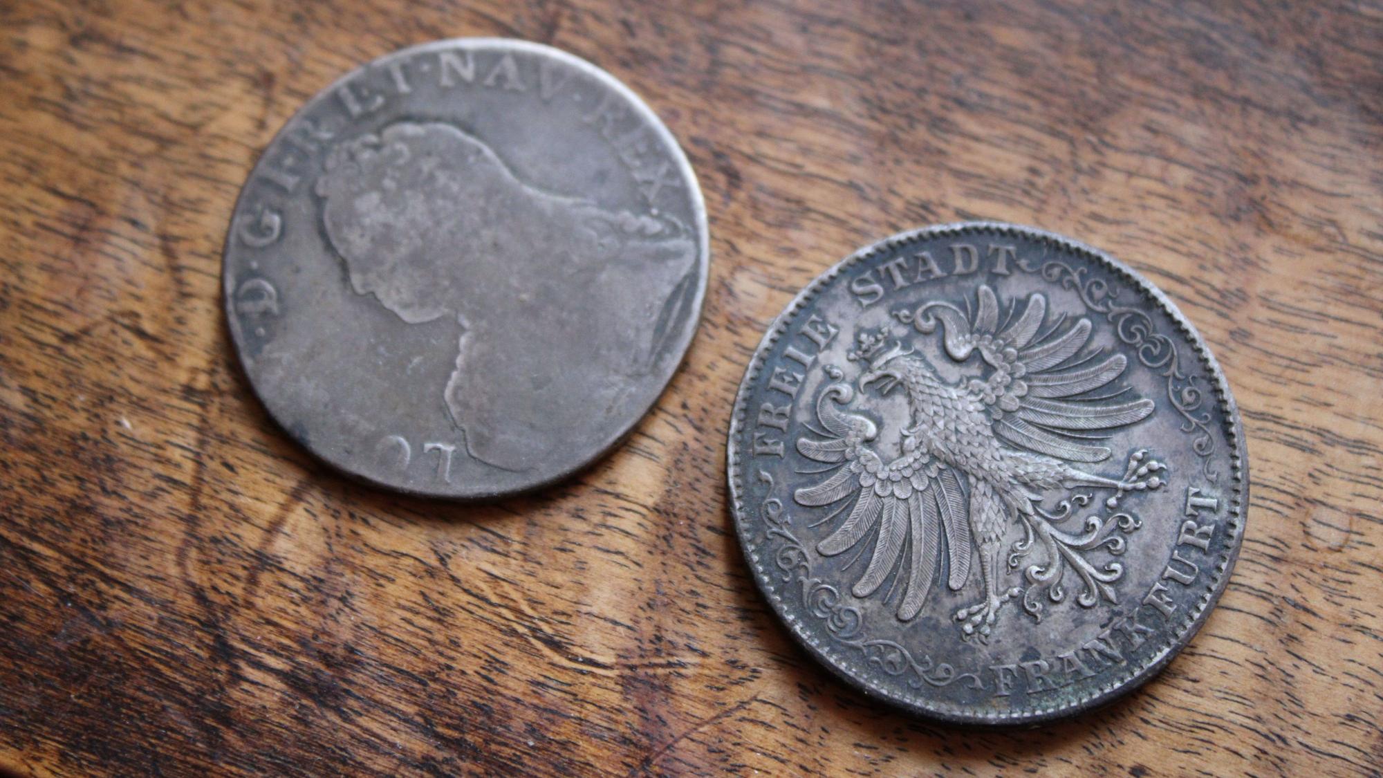 Ein Säckchen mit Napoleonischen Münzen (l.) und Frankfurter Talern (r.) wurde bei Umbauarbeiten in einer Zwischendecke gefunden.