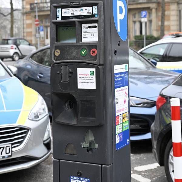 Ein klassischer Automat mit Münzfach steht am Straßenrand.