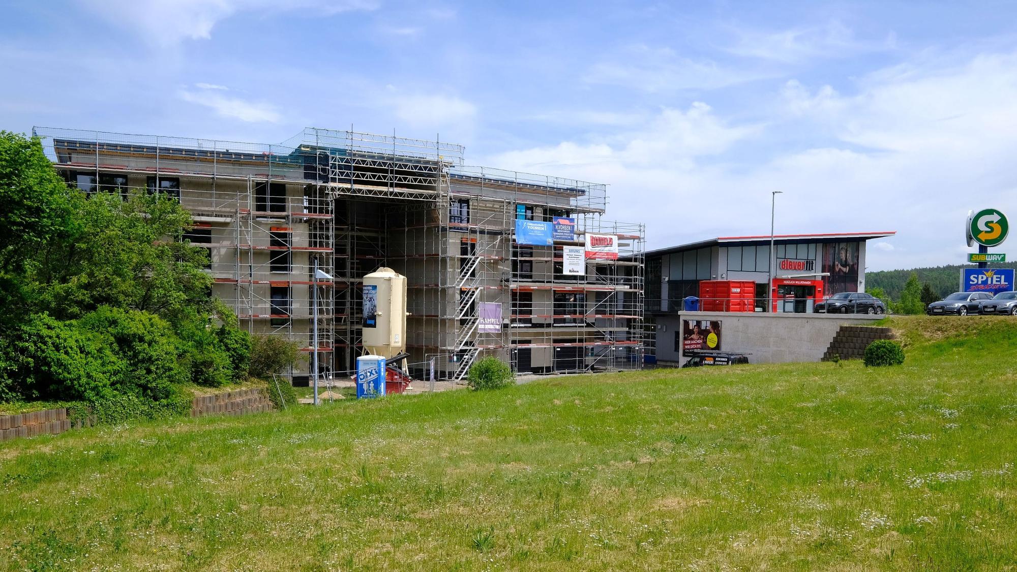 Baustelle eines neuen Gebäudes an der Bruchgasse in Mechernich. Vor dem mehrgeschossigen Rohbau steht ein Estrichsilo.