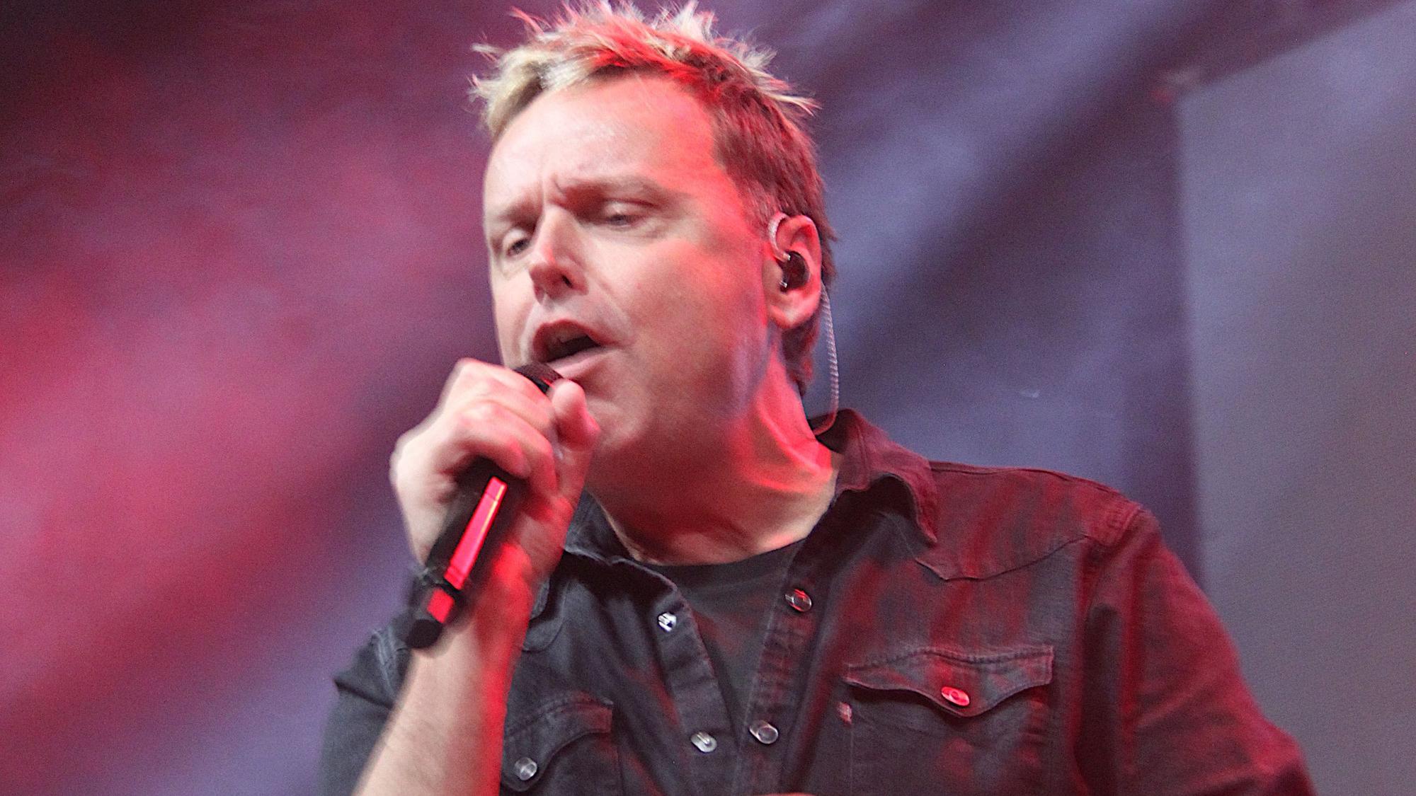 Mirko Bäumer singt in ein Mikrofon.