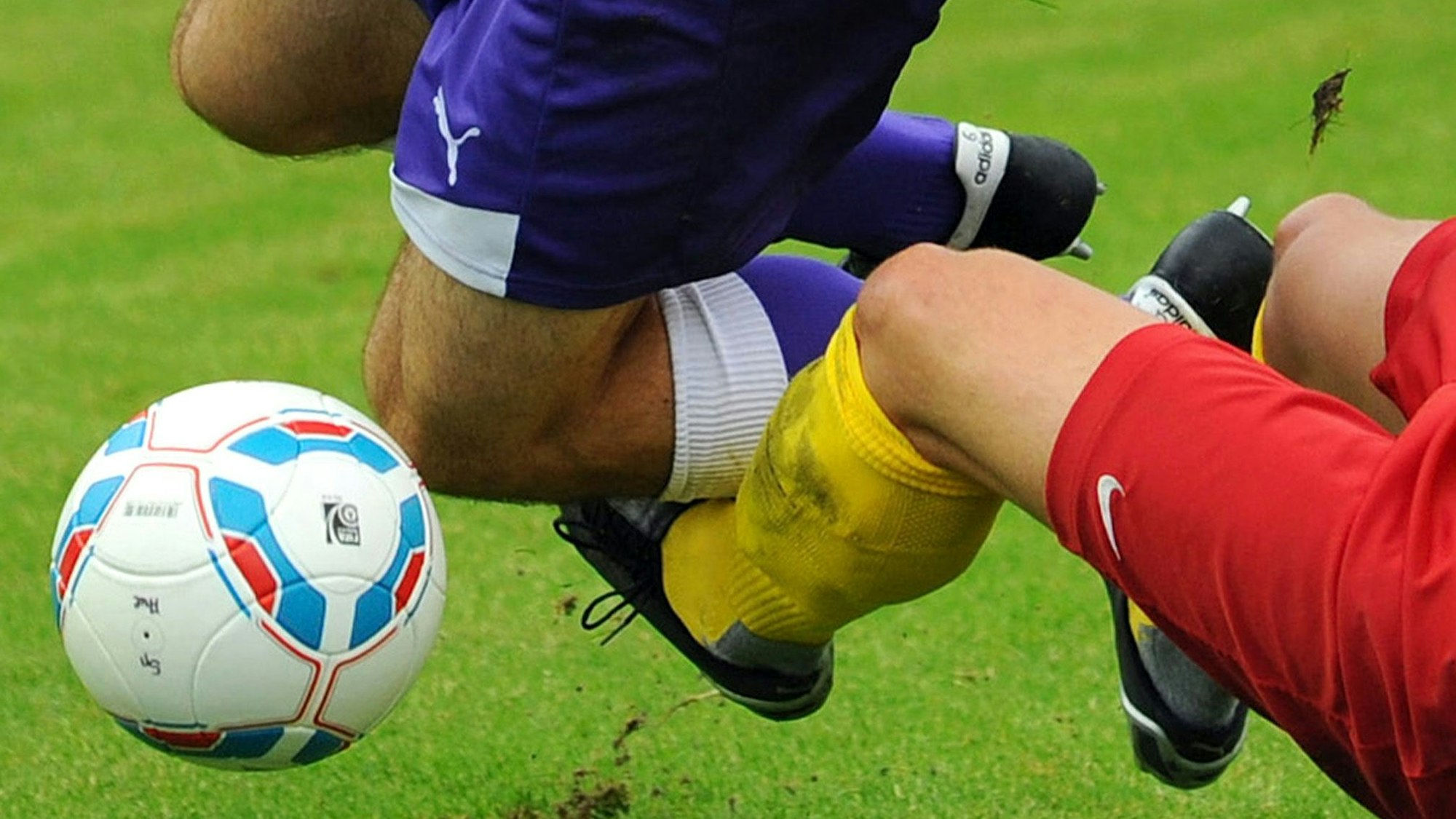 Ein Kicker wird von einem anderen zu Fall gebracht