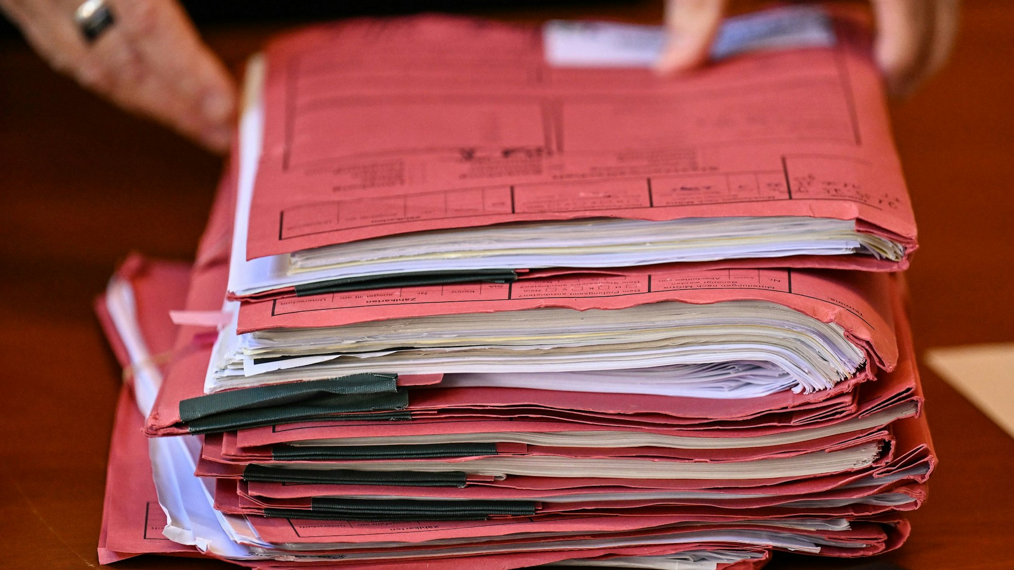 Akten liegen in einem Gerichtssaal auf einem Tisch.