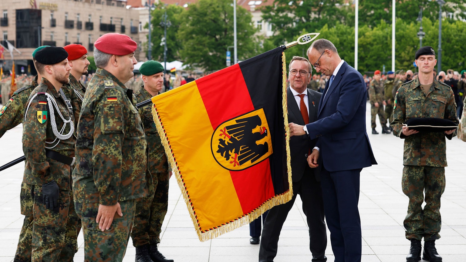 Litauen, Vilnius: Bundeskanzler Friedrich Merz (CDU, 2.v.r.) und Boris Pistorius (SPD, 3.v.r.), Verteidigungsminister, nehmen am Aufstellungsappell der Panzerbrigade 45 teil.