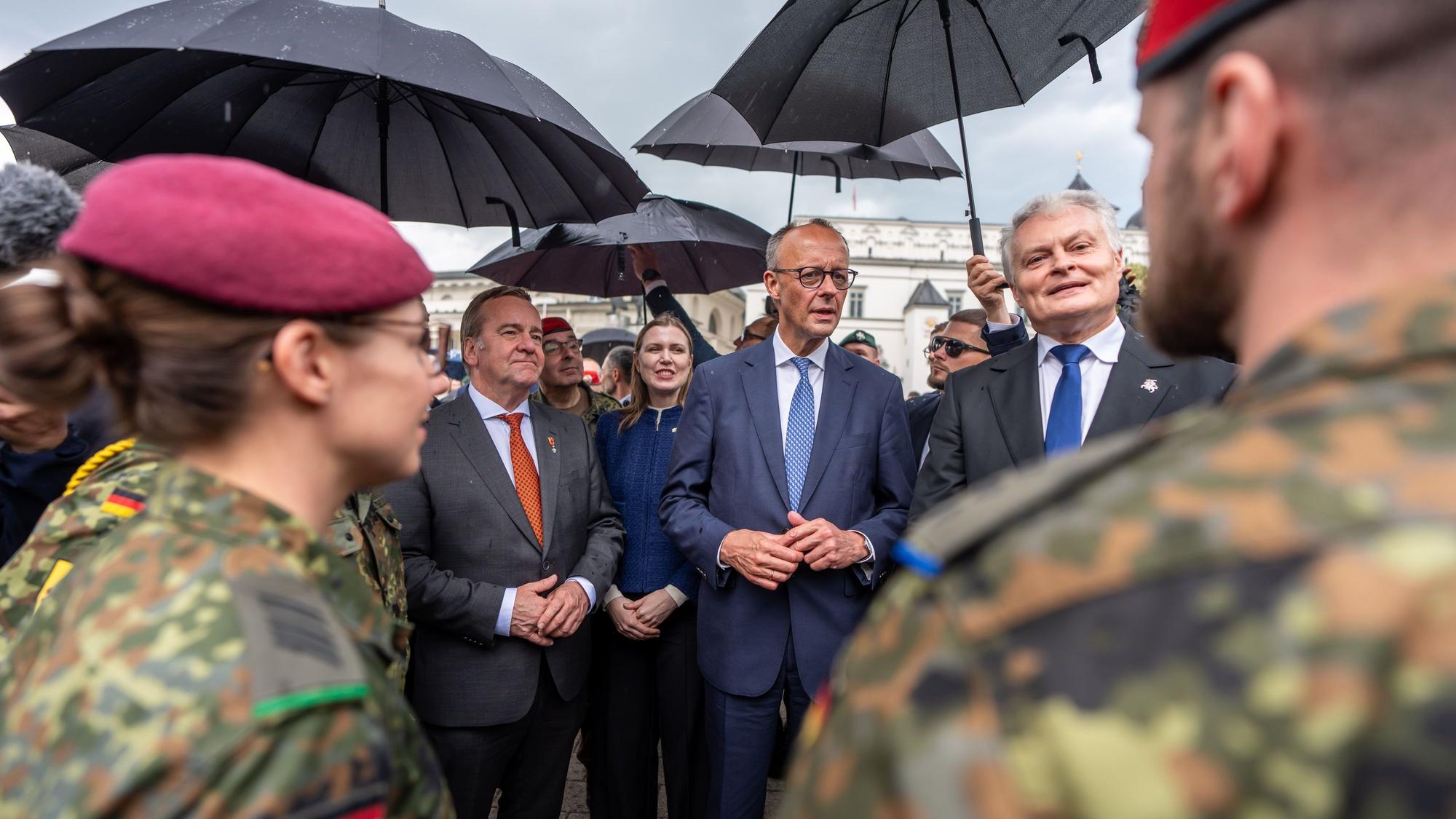 Bundeskanzler Friedrich Merz (CDU, M) steht neben Gitanas Nauseda (r), Präsident von Litauen beim Aufstellungsappell der Panzerbrigade 45.