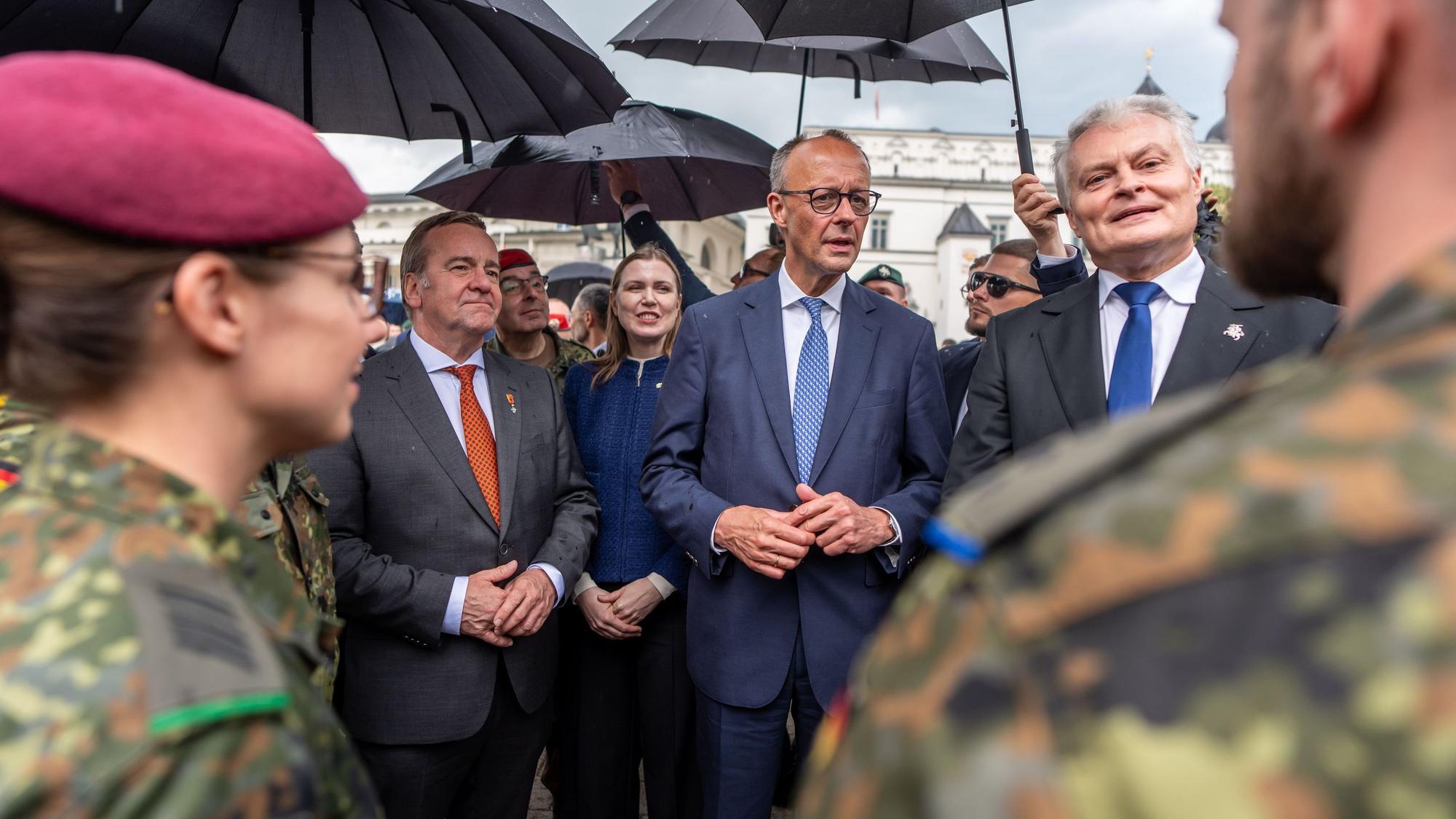 Bundeskanzler Friedrich Merz (CDU, M) zusammen mit Verteidigungsminister Boris Pistorius (SPD, 2.v.l.) im Mai bei Soldaten der in Litauen stationierten Panzerbrigade 45. (Archivbild)