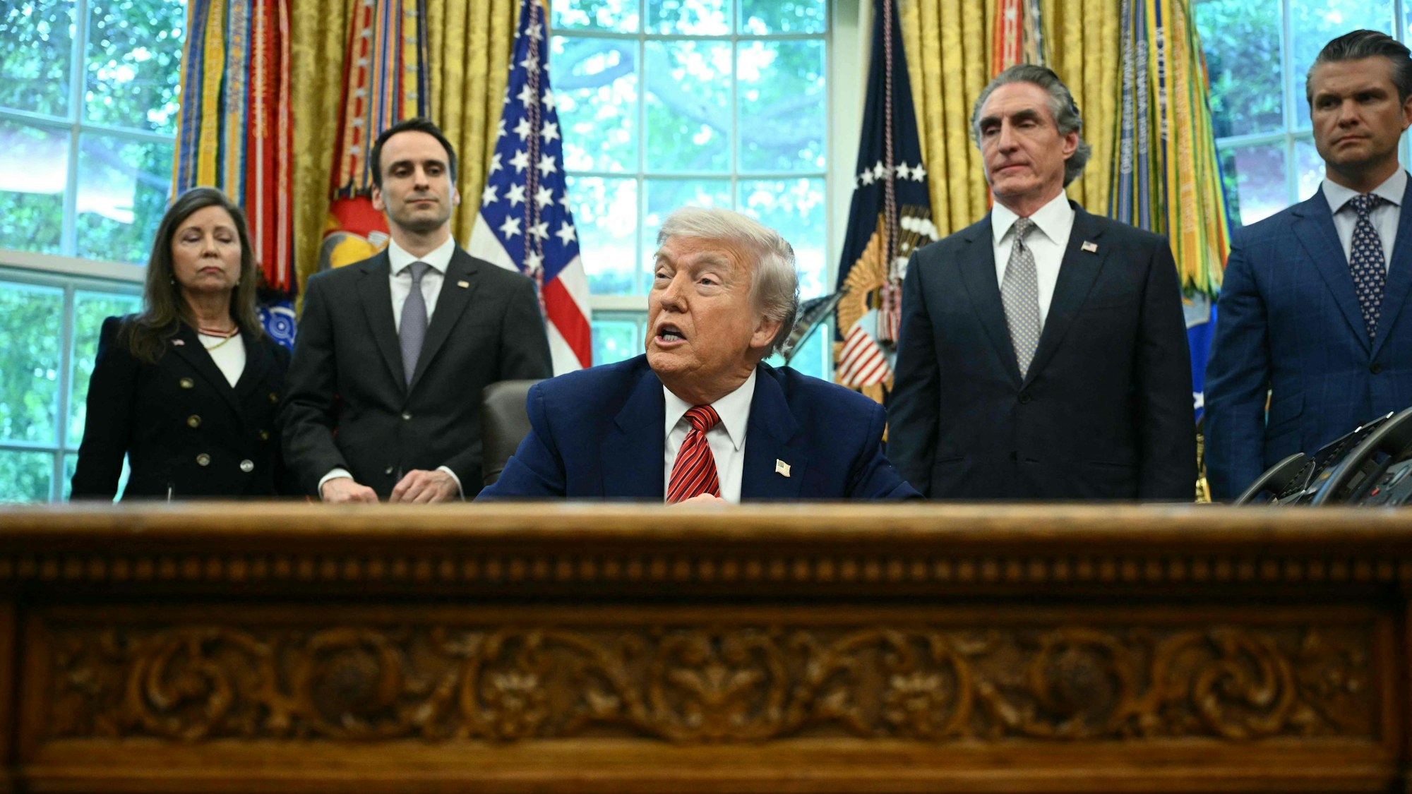 US President Donald Trump, with Secretary of Defense Pete Hegseth (R) and Secretary of the Interior Doug Burgum (2nd R) speaks after signing executive orders in the Oval Office of the White House in Washington, DC, on May 23, 2025. (Photo by Mandel NGAN / AFP)