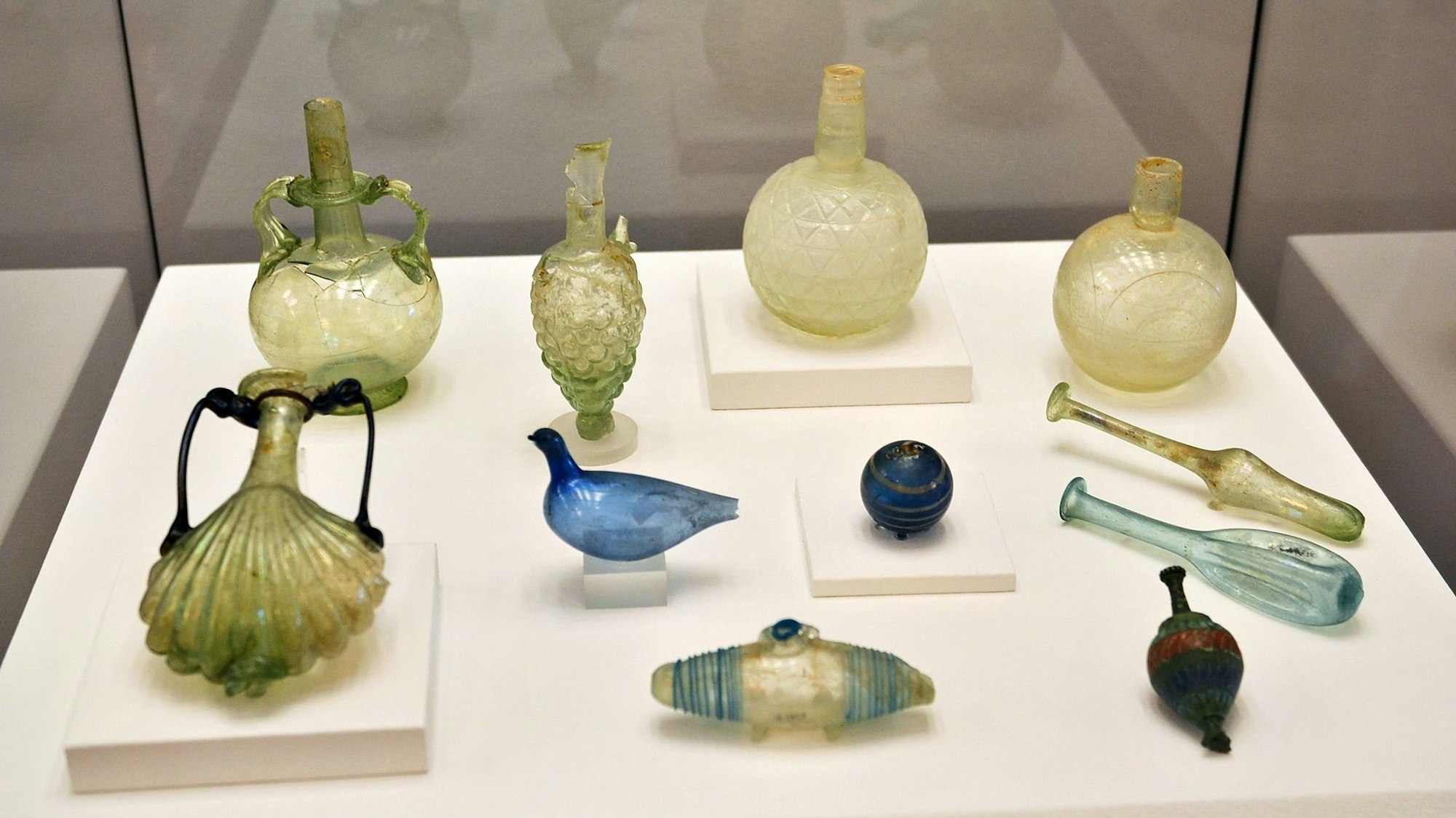 Antike Luxusgüter wie aufwändig gestaltete Parfümfläschchen sind in einer Vitrine ausgestellt.