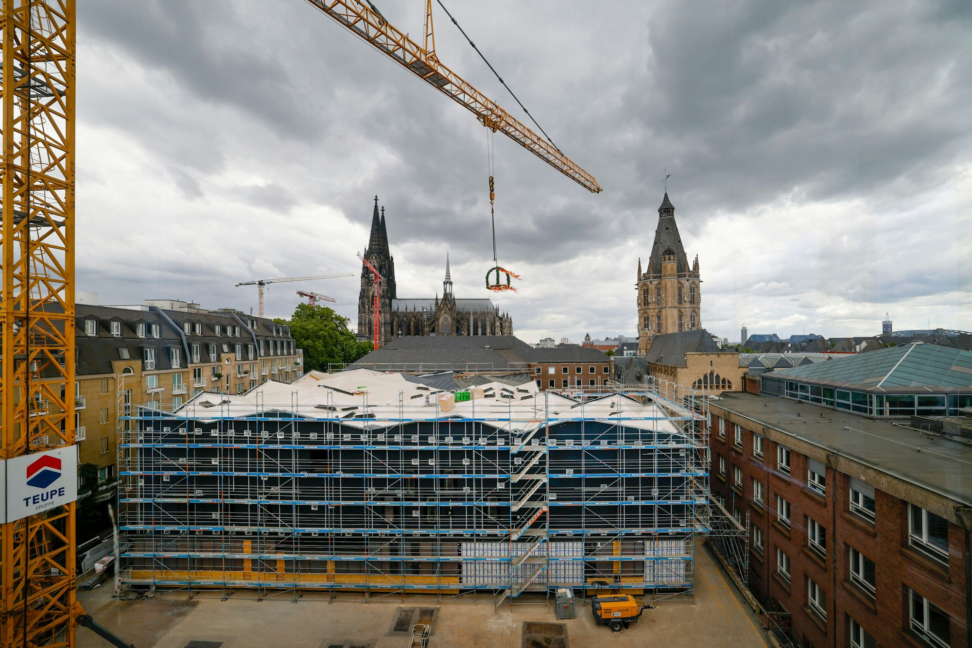 Der Richtkranz hängt über der MiQua-Baustelle am Kölner Rathaus, gesehen vom Wallraf-Richartz-Museum aus.