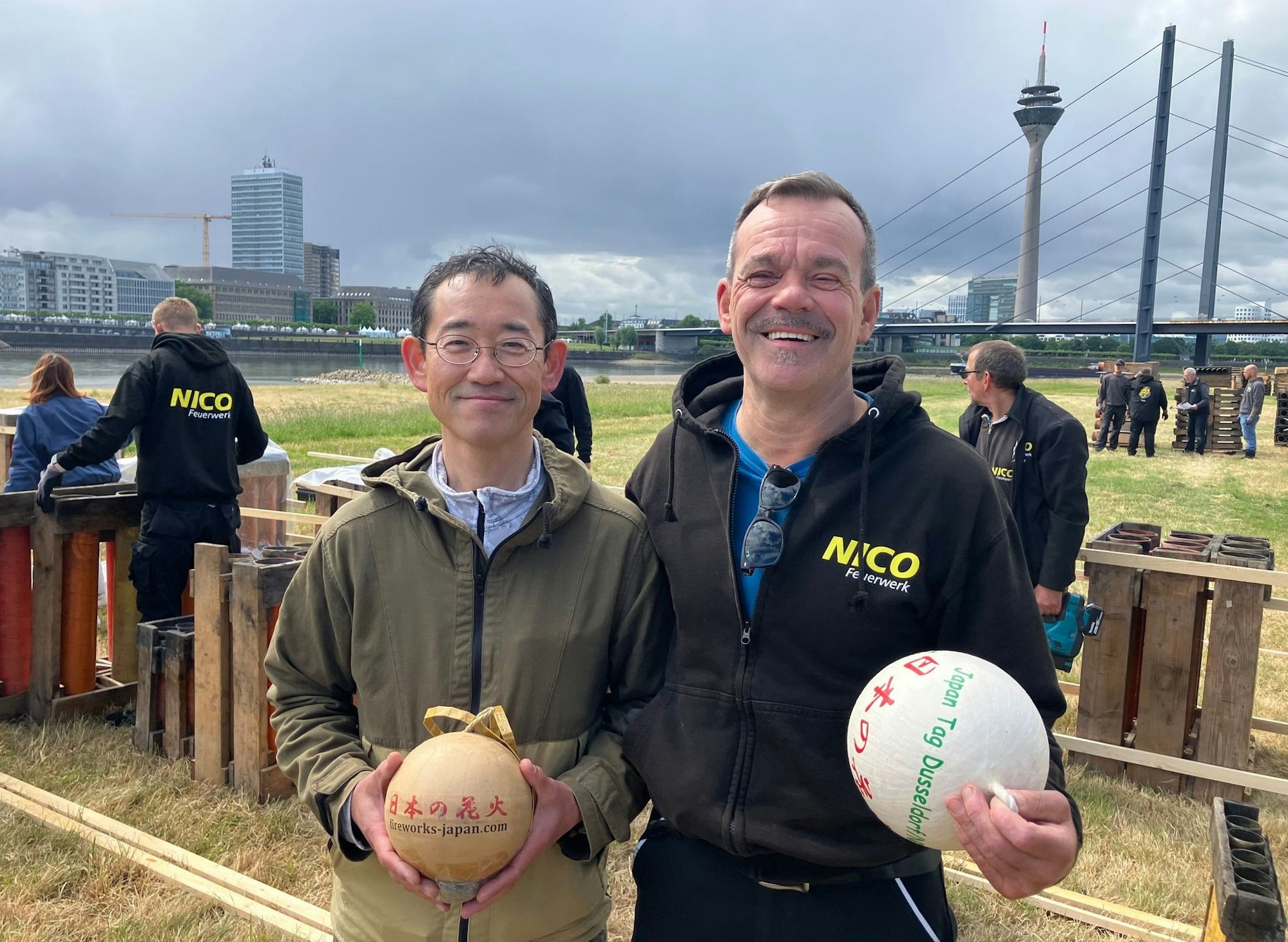 Die Pyrotechniker Hideki Kubota (l) und Martin Schmitz stehen beim Aufbau des japanischen Feuerwerks zusammen.