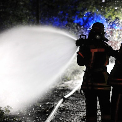 Das Bild zeigt Feuerwehrkräfte beim Löschen eines Waldbrandes.