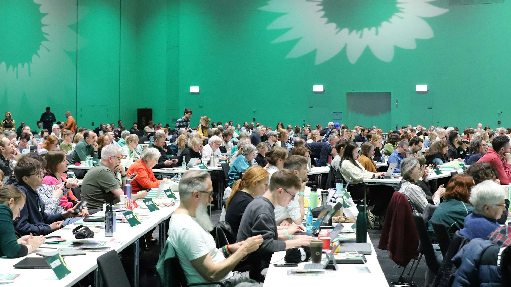 24.05.2025, Nordrhein-Westfalen, Köln: Deligierte sitzen an Tischen. Die nordrhein-westfälischen Grünen treffen sich am Samstag (10.30 Uhr) zu ihrem Landesparteitag in Köln. Nach dem eher ernüchternden Abschneiden bei der Bundestagswahl wollen sie nun die Weichen für die Kommunalwahl im September stellen. (zu dpa: «Banaszak stimmt NRW-Grüne auf Kommunalwahl ein») Foto: Sascha Thelen/dpa +++ dpa-Bildfunk +++