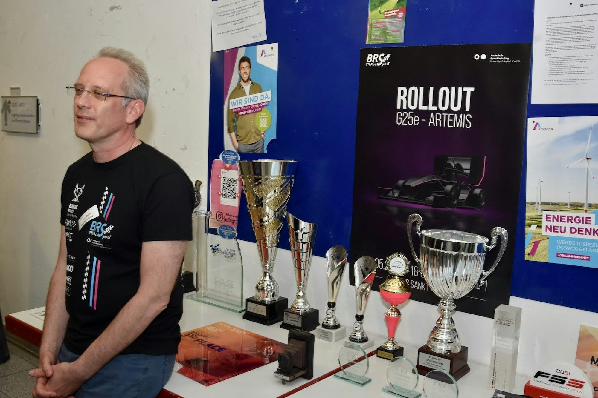Professor Dirk Reith vor der Trophäensammlung der Motorsportgruppe.
