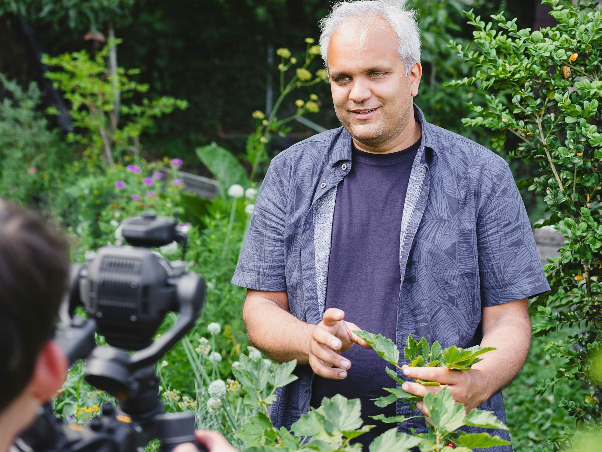 Auf dem Bild ist ein Mann zu sehen, der für einen Video gefilmt wird.