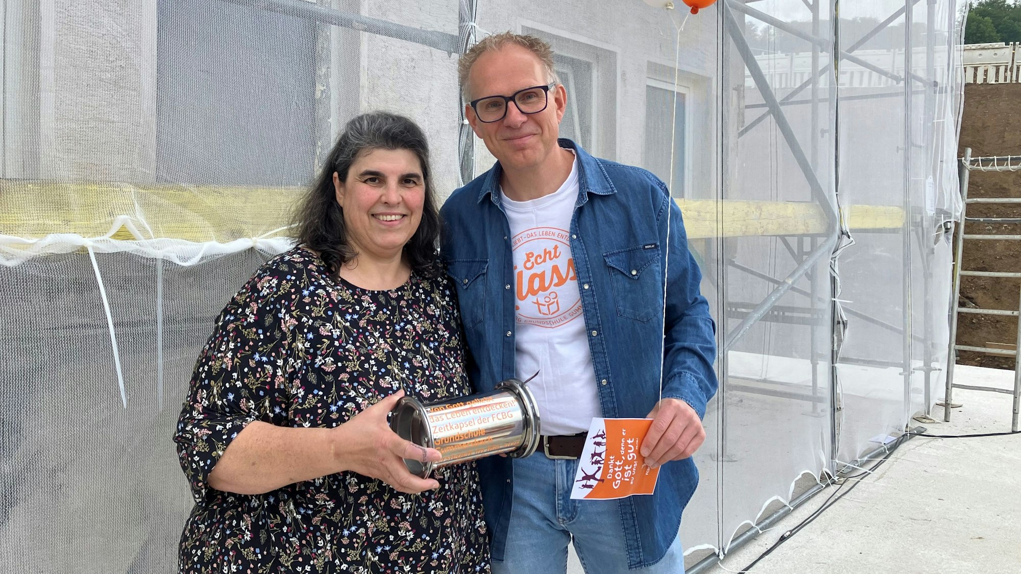 Eine Frau überreicht einem Mann eine Zeitkapsel.