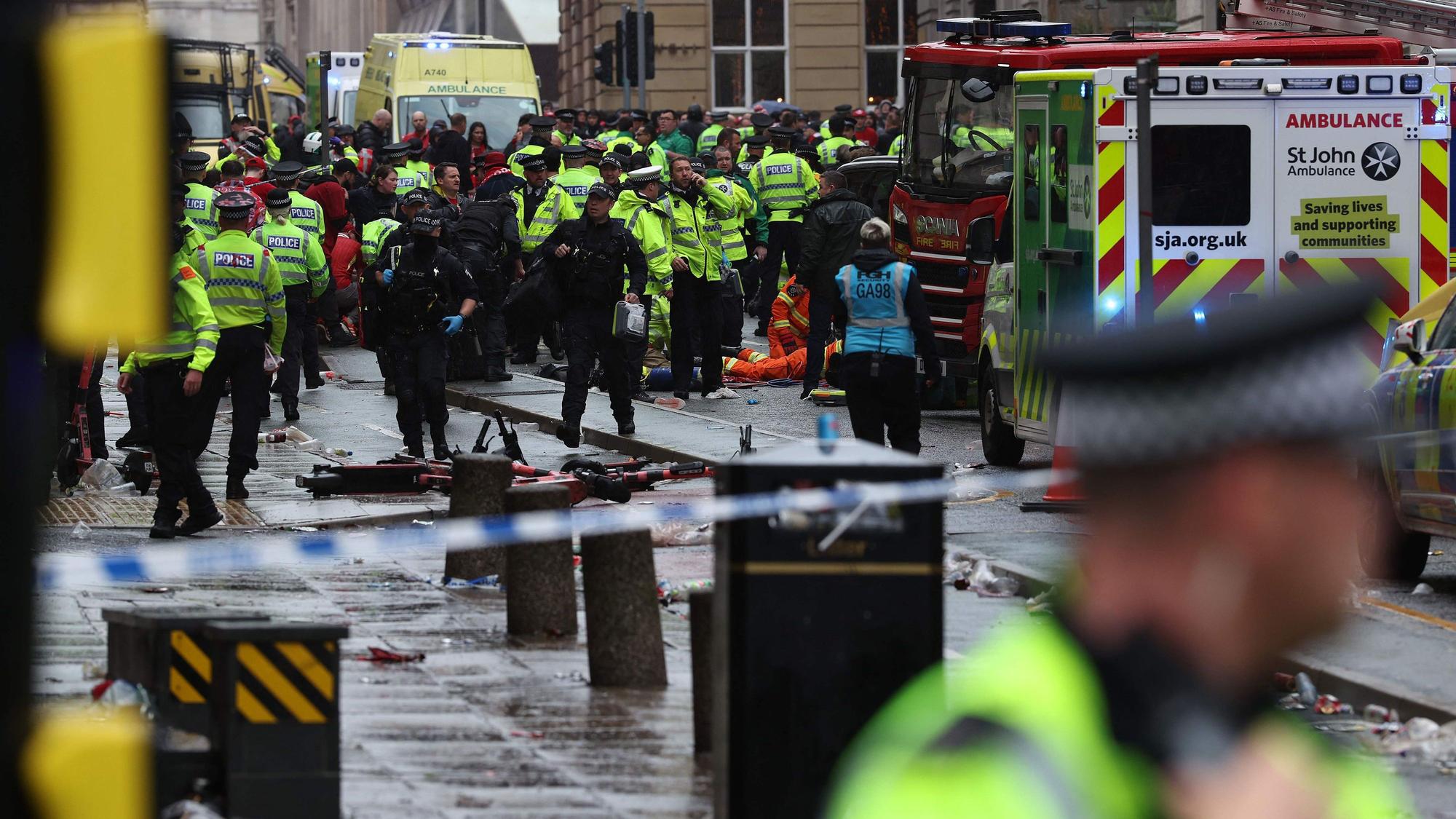 Members of the emergency services treat members of the public inside a Police cordon at the scene of an incident, on the sidelines of an open-top bus victory parade for Liverpool's Premier League title win, in Liverpool, north-west England on May 26, 2025. (Photo by Darren Staples / AFP)
