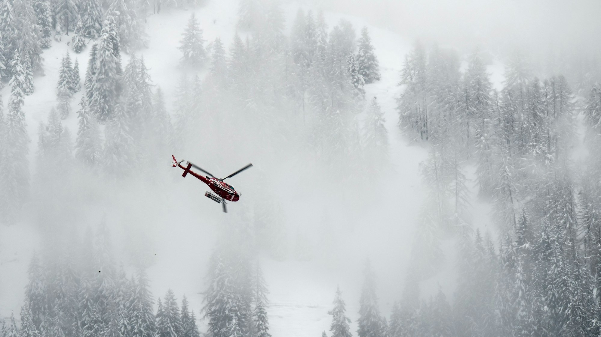 ARCHIV - 31.03.2018, Schweiz, Fiesch: Ein Helikopter der Firma Air Zermatt fliegt über die Fiescheralp. (zu dpa: «Fünf Skitourengänger im Wallis tot aufgefunden») Foto: Jean-Christophe Bott/KEYSTONE/dpa +++ dpa-Bildfunk +++