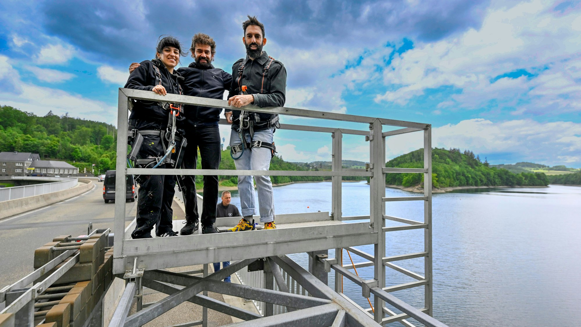 Künstler stehen in einem Hängegerüst.