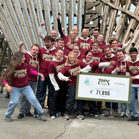 Zu sehen ist eine Gruppe von Leuten, die einen symbolischen Scheck halten.