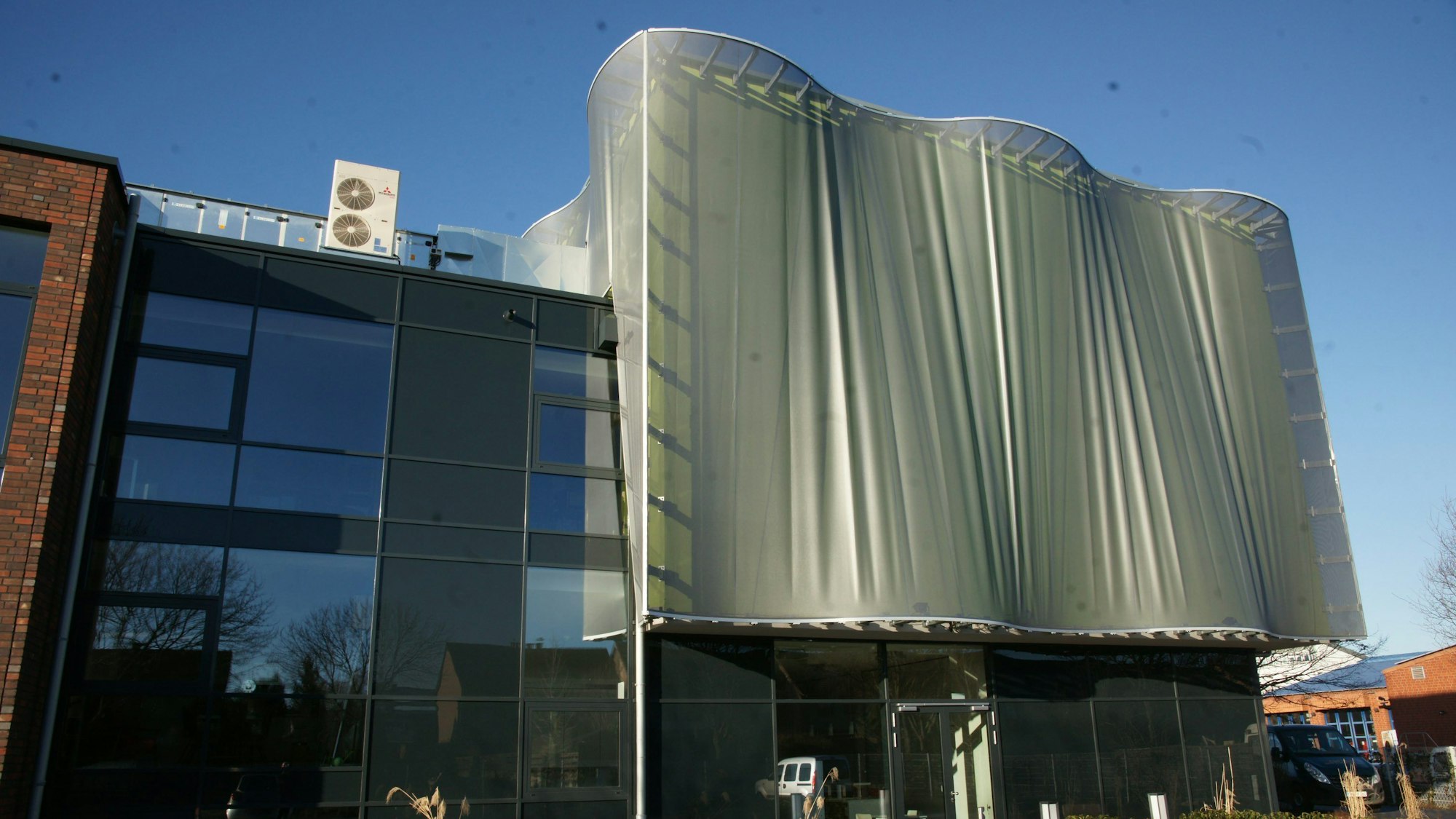 Zu sehen ist ein graues Gebäude.