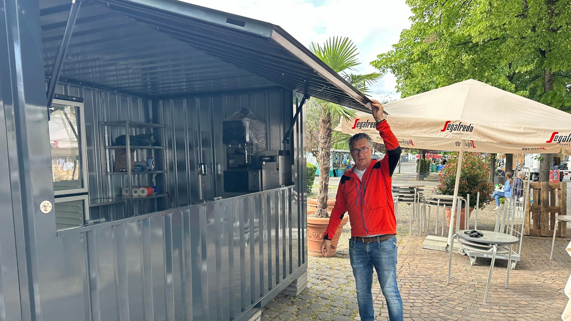 Die Klappe am Ausgabecontainer wird von Kellner Giovanni geprüft.