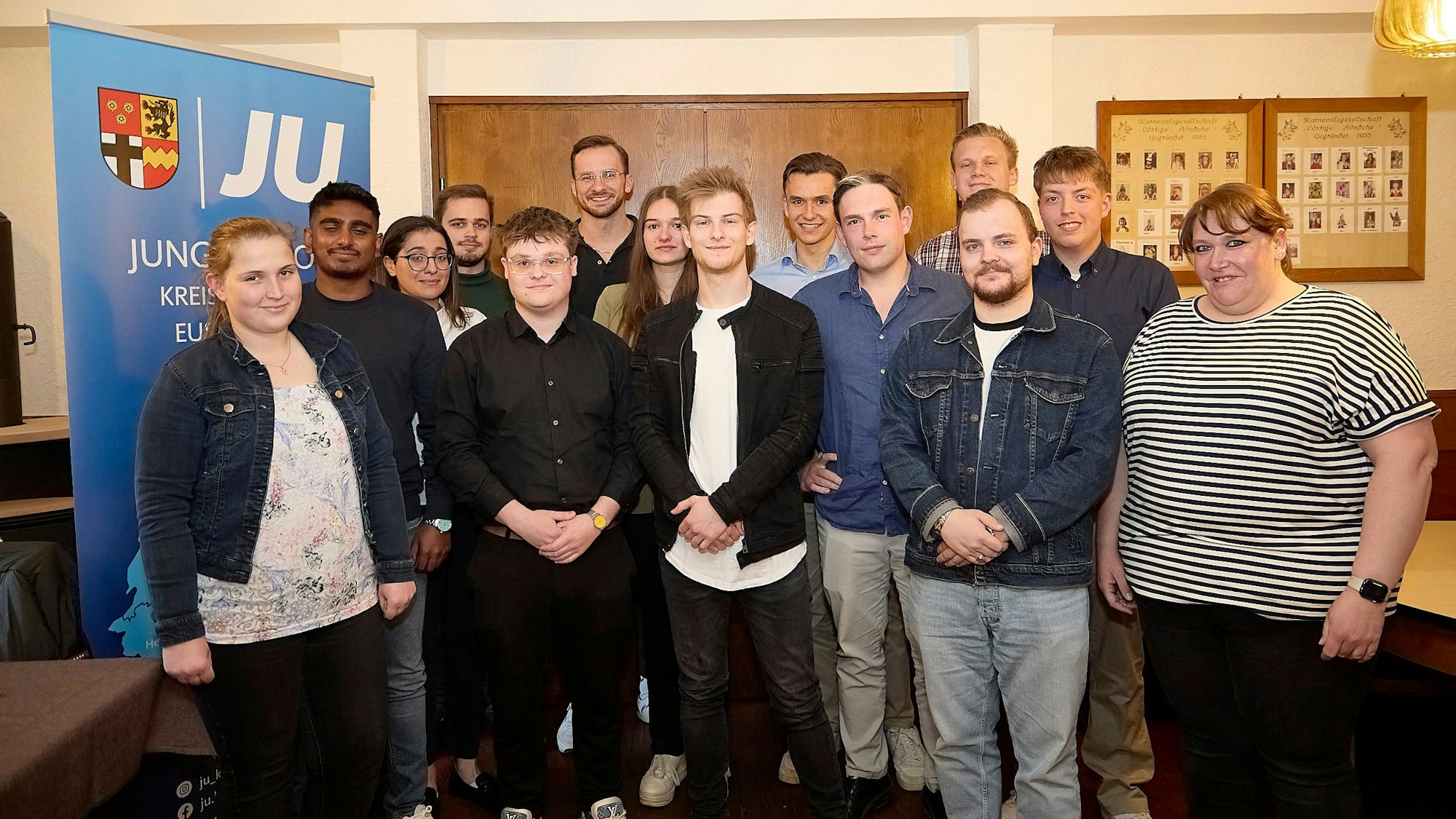 Eine Gruppe junger Frauen und Männer posiert neben einem Plakat der Jungen Union.