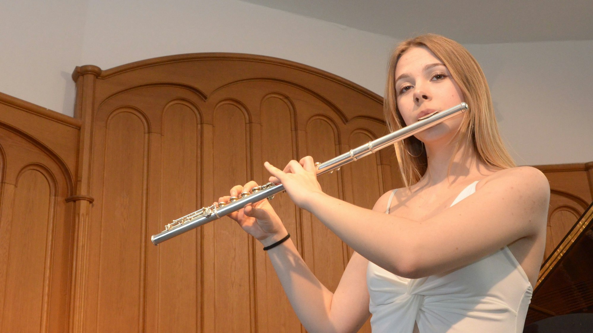 Die Flötistin spielt auf ihrem Instrument.