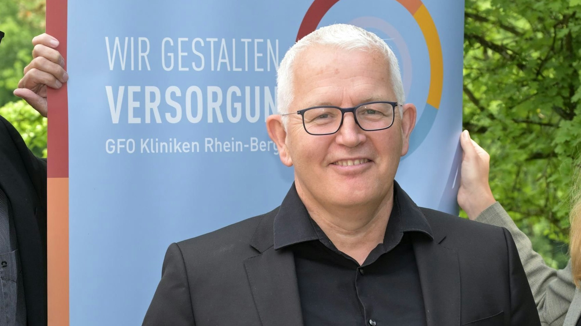 Leiter des Darmkrebszentrums, Pascal Scherwitz, hat weiße kurze Haare und eine schwarze Brille.