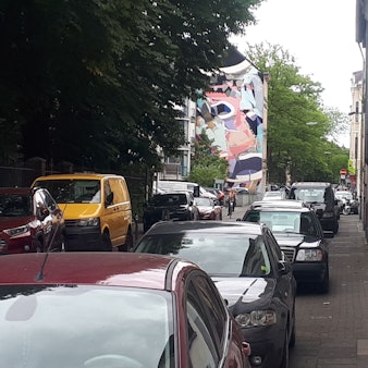 Ein Gehweg ist fast komplett von Autos zugeparkt.