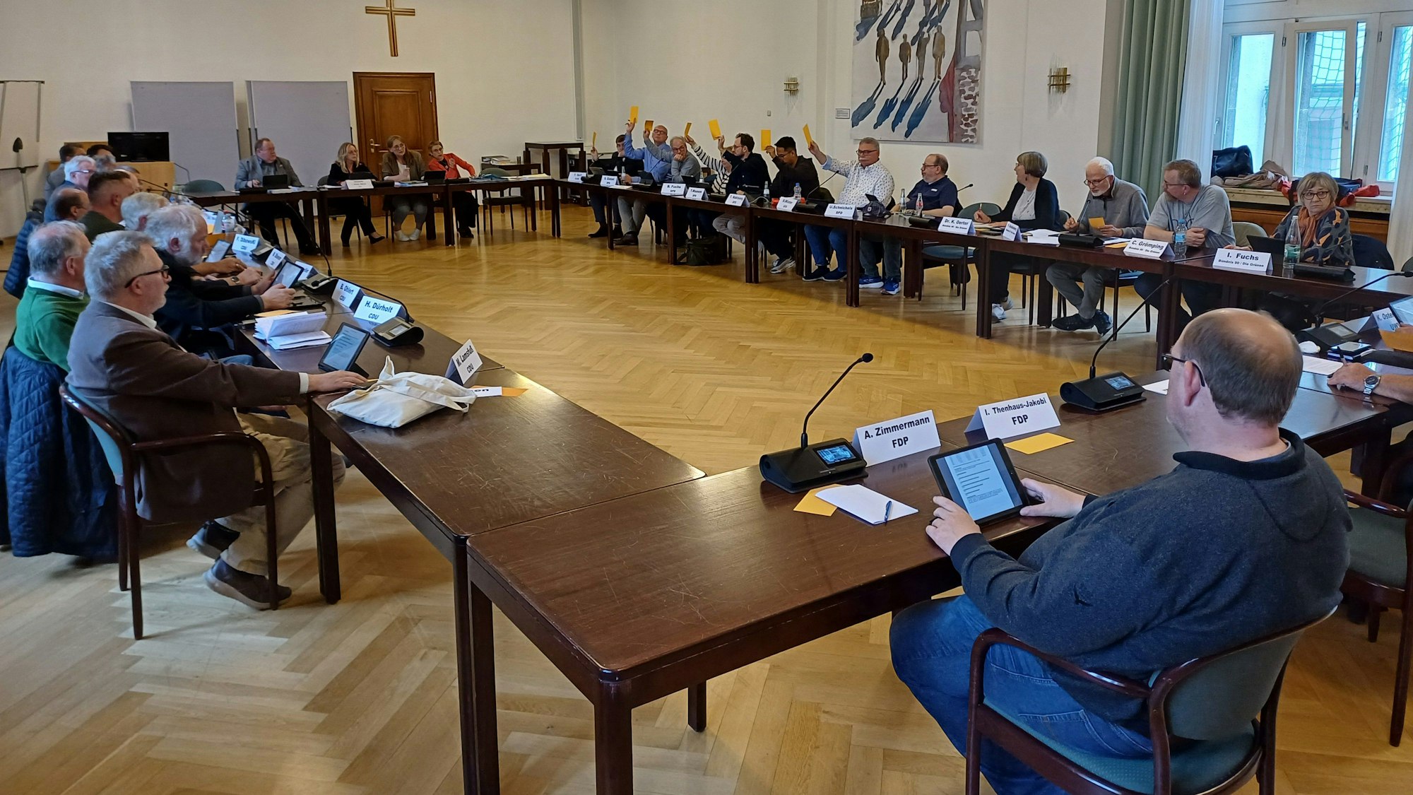 Mitglieder der SPD und des BSW zeigen in einer Abstimmung im Bad Münstereifeler Stadtrat auf.
