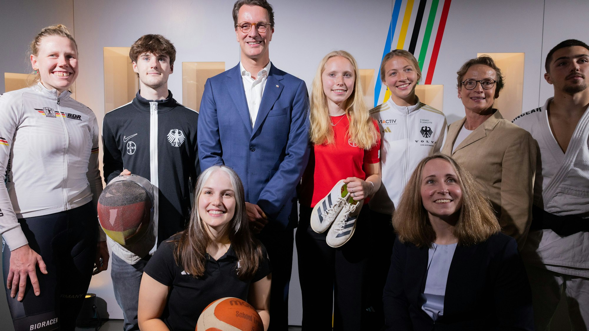 28.05.2025, Nordrhein-Westfalen, Köln: Hendrik Wüst (hinten 3.v.l, CDU), Ministerpräsident von Nordrhein-Westfalen, steht zusammen mit Sportlern und Olympiasiegerin Isabell Werth (hinten 2.v.r) bei der Vorstellung des Konzepts einer Olympia-Bewerbung mit der Rhein-Ruhr-Region für die Olympischen Spiele. Foto: Rolf Vennenbernd/dpa +++ dpa-Bildfunk +++