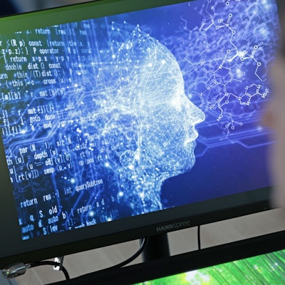 Das Bild zeigt einen jungen Mann vor einem Bildschirm.