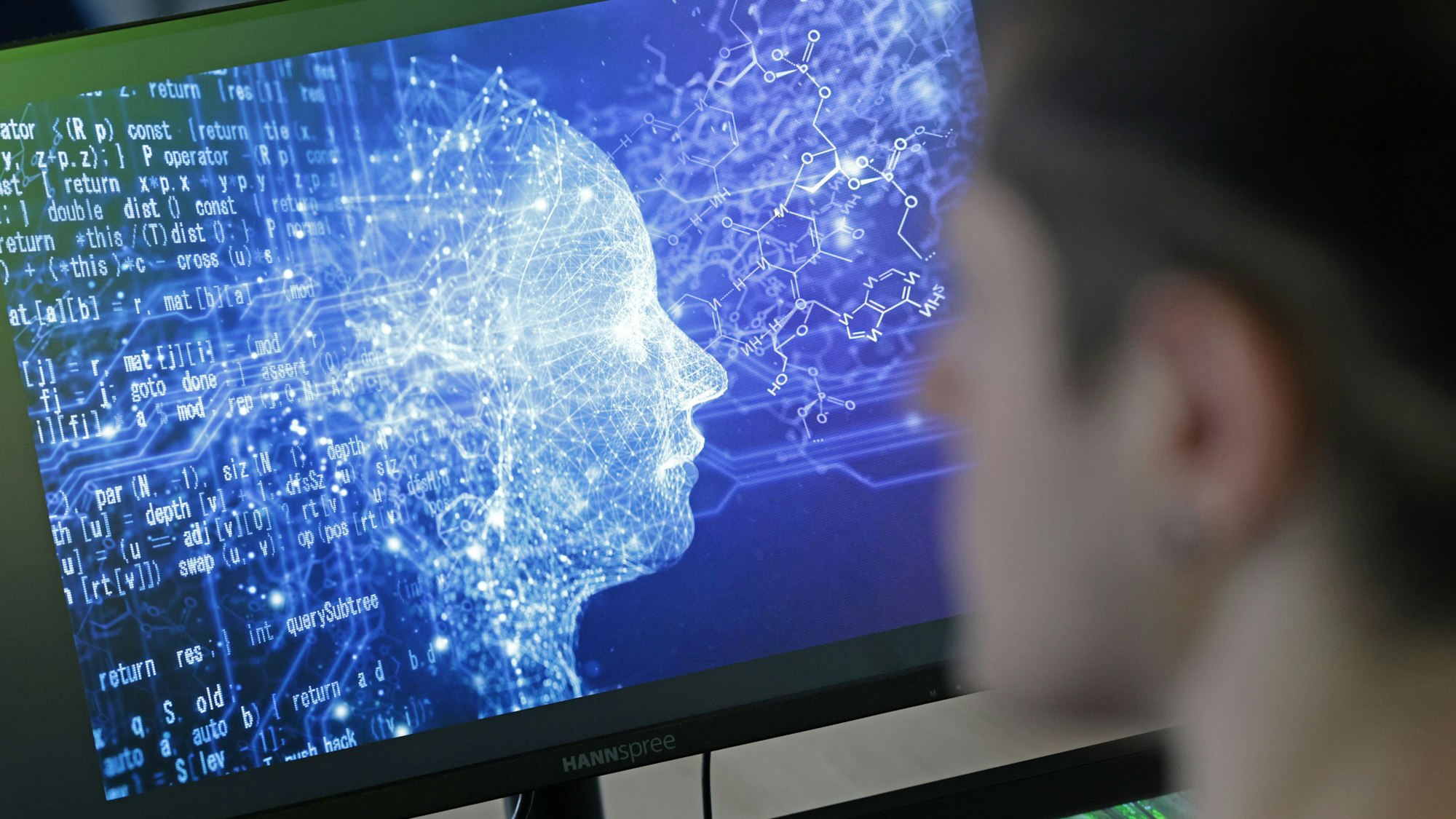 Das Bild zeigt einen jungen Mann vor einem Bildschirm.