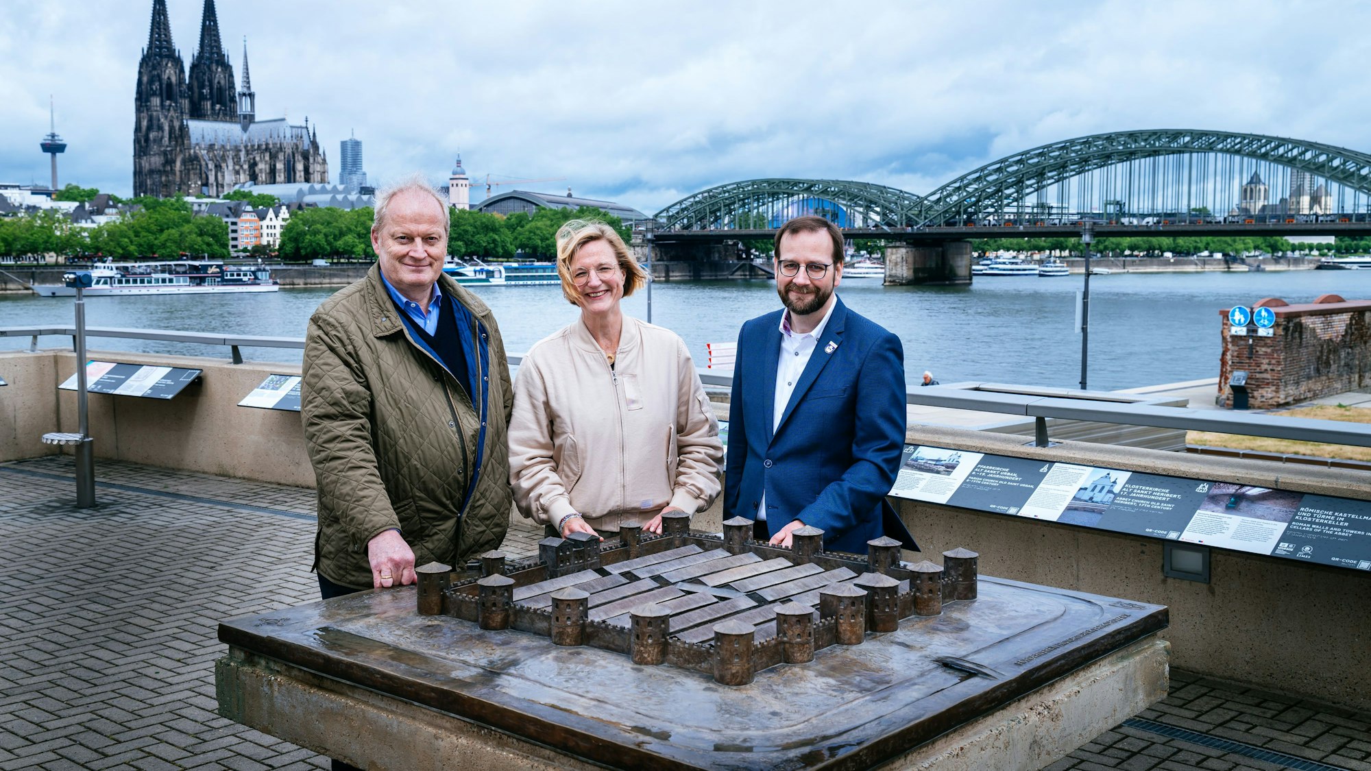 Dr. Marcus Trier (v. l.), Melanie Ihlenfeld und Sascha Ringling vom Förderverein Historischer Park Deutz stehen dort, wo einst das Kastell Divitia stand, an dessen maßstabsgetreuem Bronzemodell.
