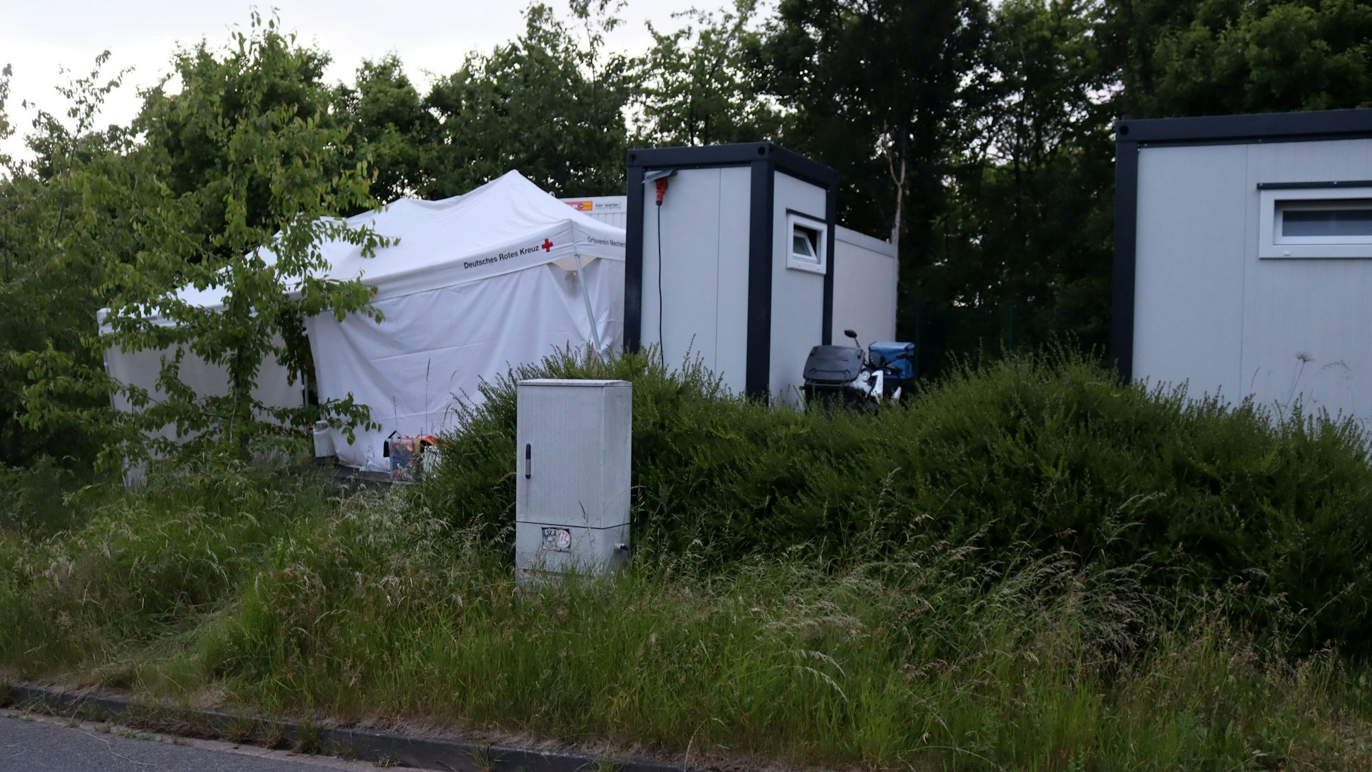Vor den Wohncontainern der Stadt haben die Ermittler der Bonner Polizei ein weißes Zelt aufgebaut, um Spuren zu sichern.