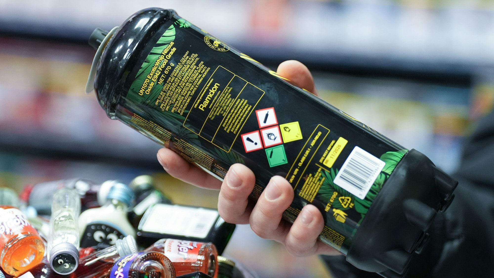 Ein Mitarbeiter hält eine Dose Lachgas am Tresen eines Kiosks in der Hand. Symbolfoto.