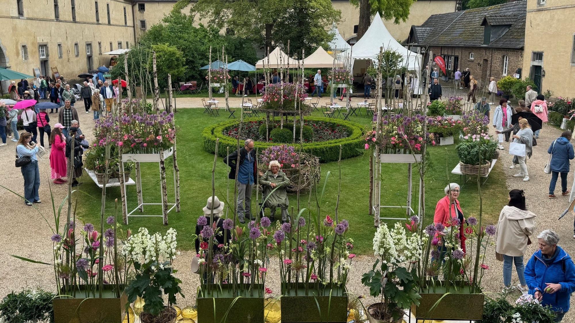 Blick in den mit Blumen geschmückten Innenhof der Wasserburg Adendorf.