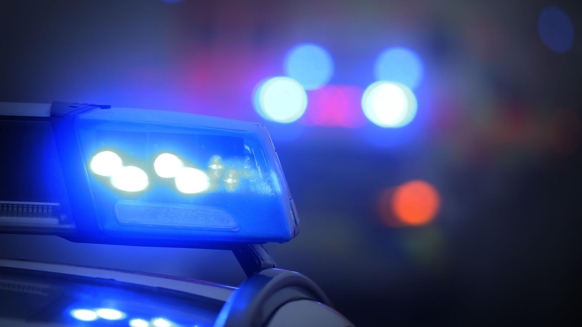 Ein Polizeiauto mit eingeschaltetem Blaulicht steht an einer Unfallstelle.