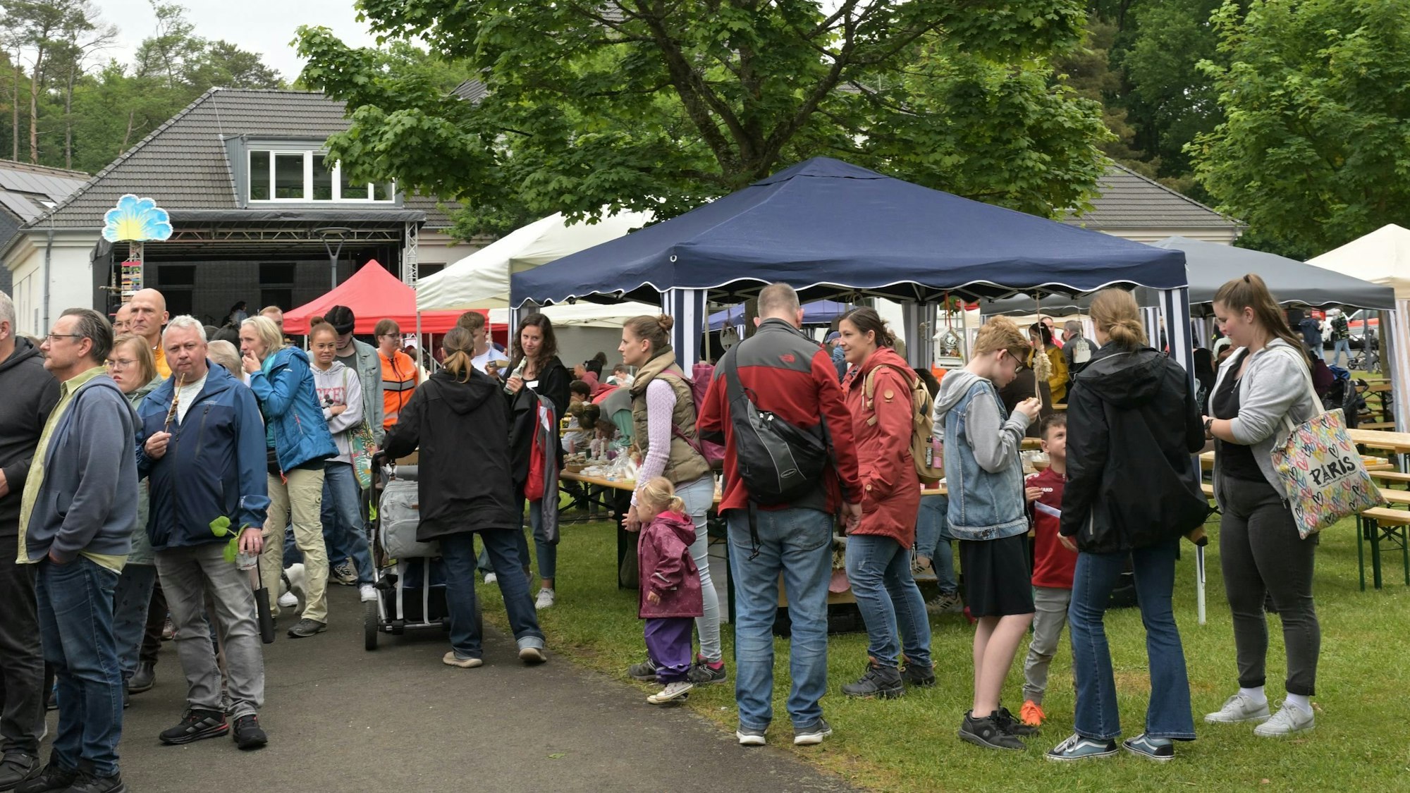 Viele Menschen tummeln sich vor Zelten und Bierbänken.