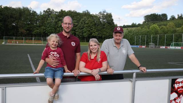 Blick auf drei Erwachsene und ein Kind, die auf dem Sportplatz in Frielingsdorf stehen.