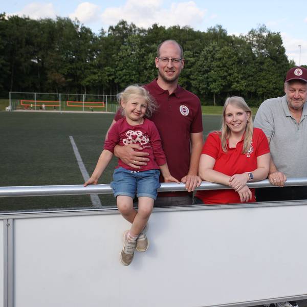 Blick auf drei Erwachsene und ein Kind, die auf dem Sportplatz in Frielingsdorf stehen.