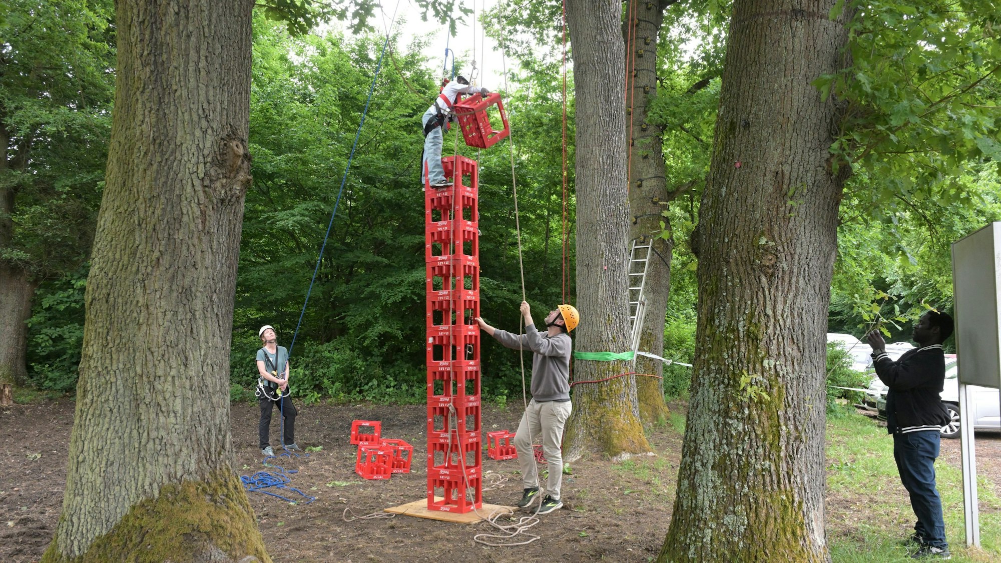 Ein Kind klettert auf einen Stapel aus roten Kästen.
