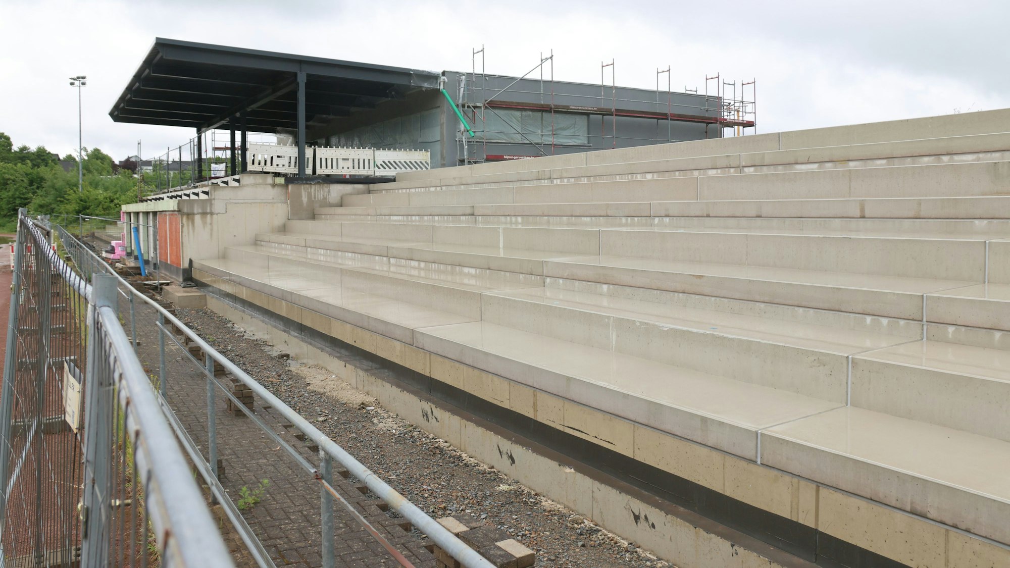 Schnappschuss von der Baustellenbesichtigung beim neuen Nümbrchter Sportlerheim. Im Vordergrund die Betontribünen.