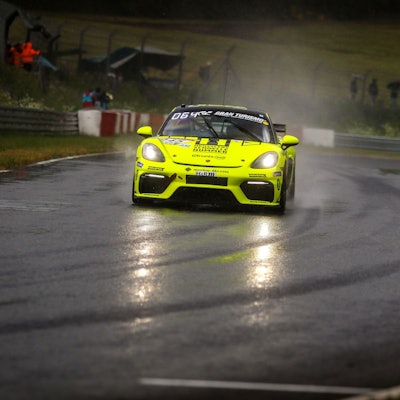 Der Porsche von mcchip fährt auf der regennassen Rennstrecke.