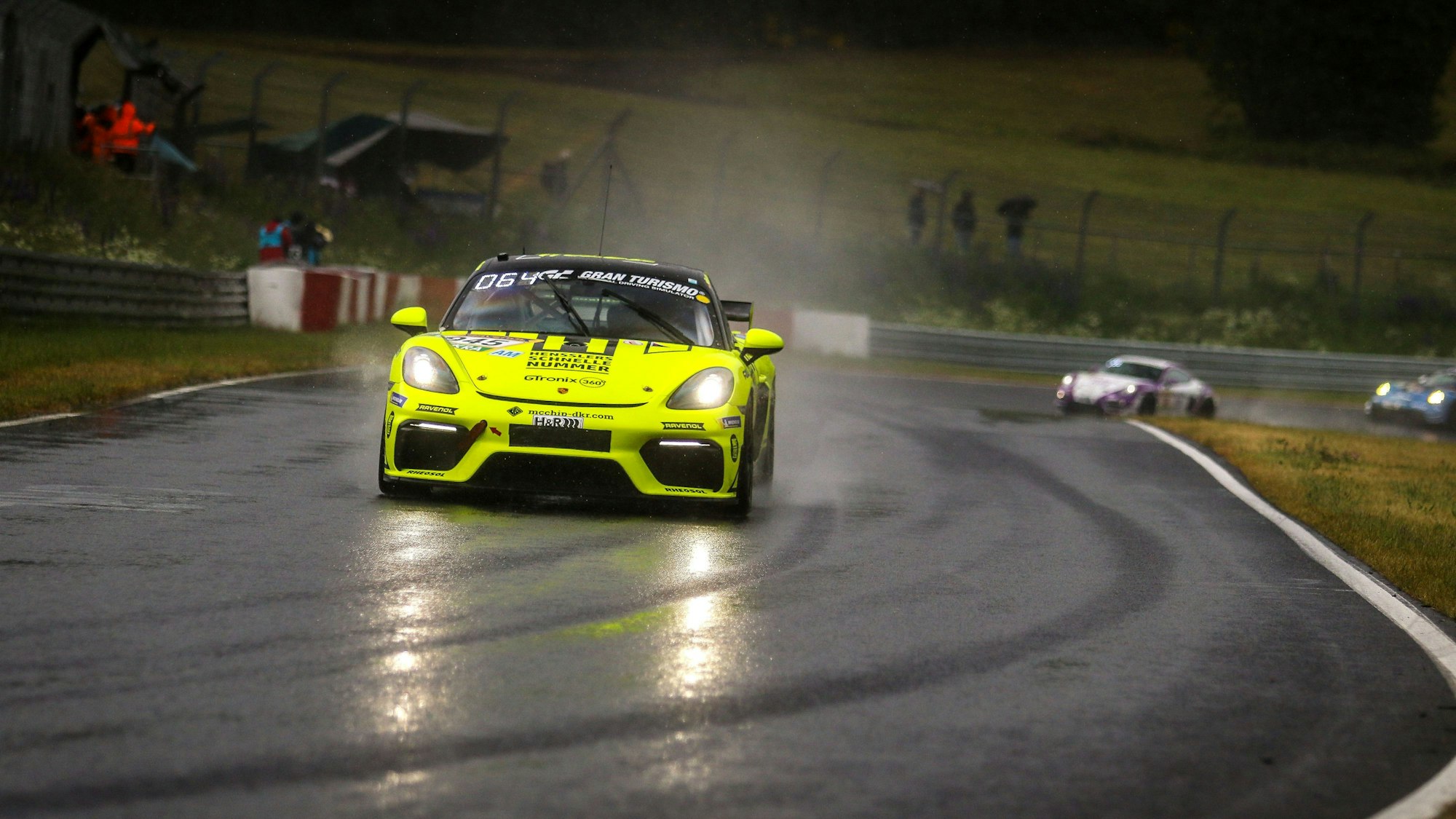 Der Porsche von mcchip fährt auf der regennassen Rennstrecke.