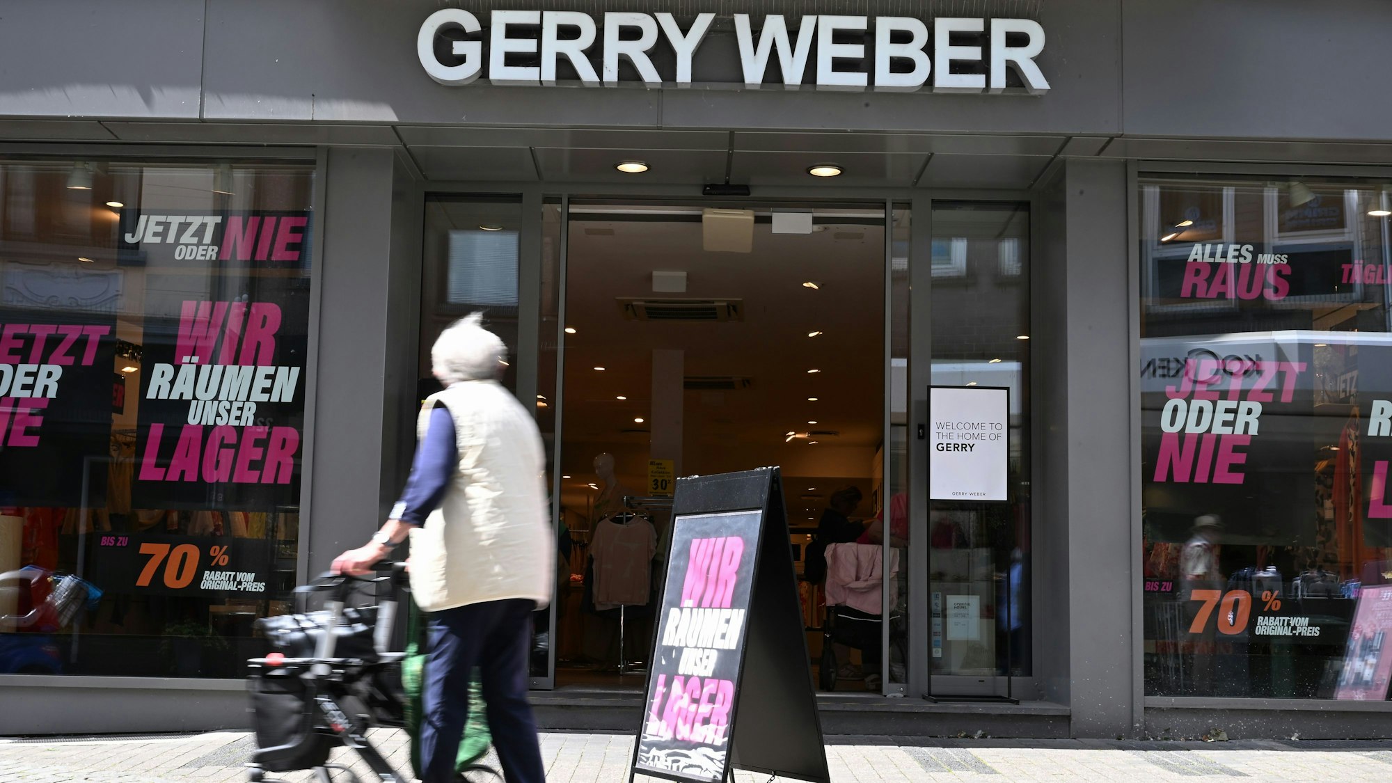 Eine ältere Dame geht an einer Filiale der Damenmode-Firma Gerry Weber in Düsseldorf vorbei. Das Unternehmen ist insolvent und schließt alle seine Filialen.